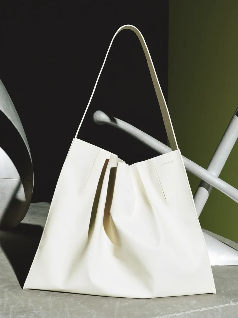 Illustration: asymmetrisch gefaltete Lederschultertasche ohne Logos